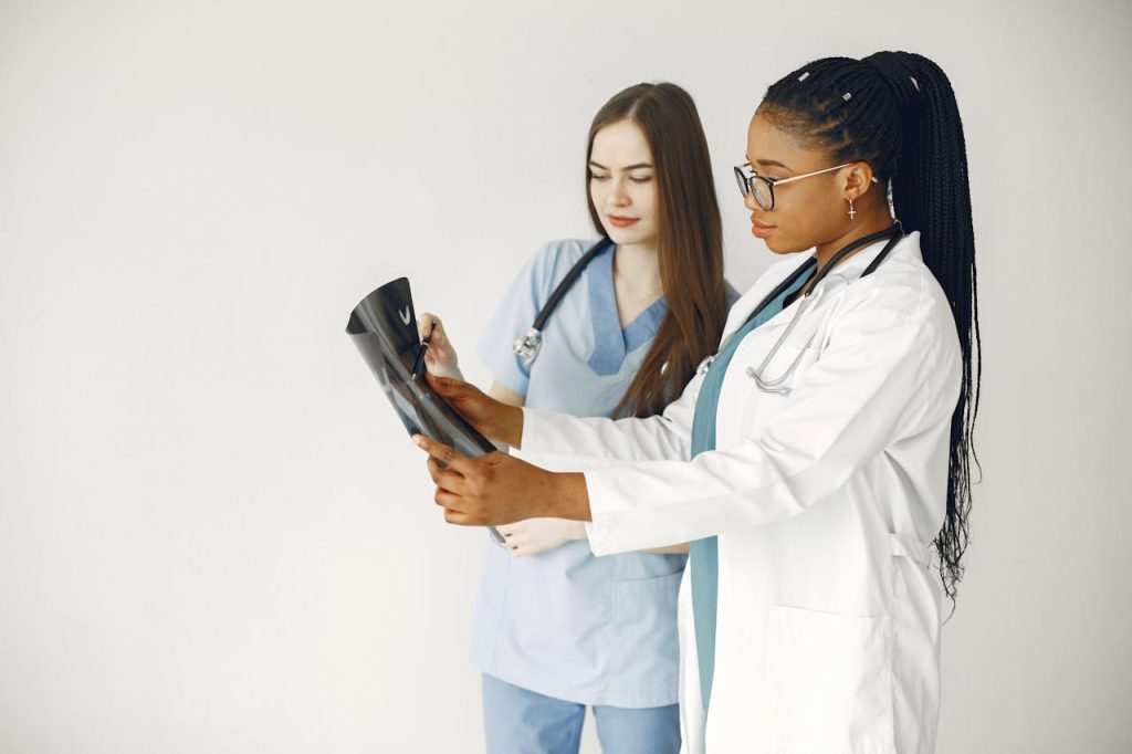 Two healthcare professionals review x-ray results in a clinical setting.
